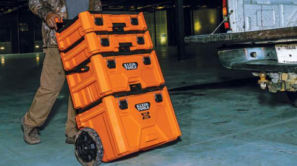 Man rolling a Klein Tools toolbox toward truck bed